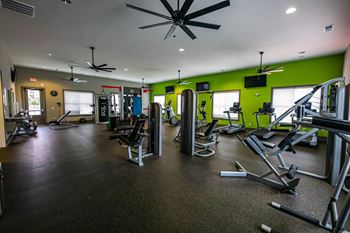 A gym with a variety of equipment including treadmills, weights, and exercise machines.